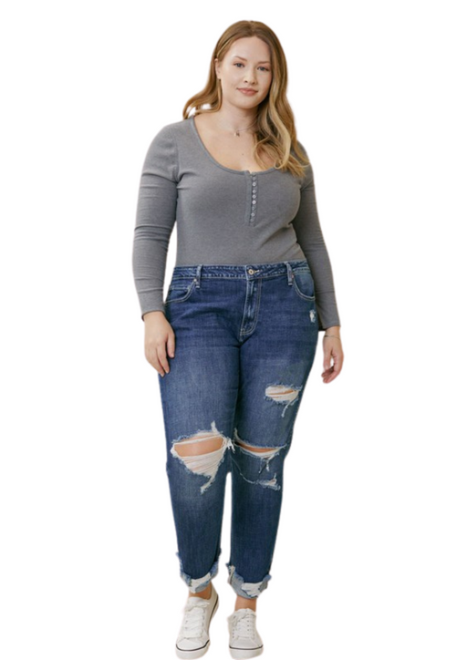a woman wearing a grey top and ripped jeans