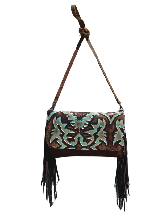 a brown and blue stamped leather purse with fringe on it hanging from a strap