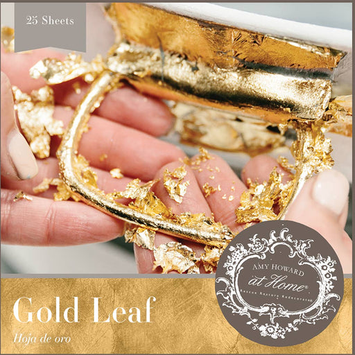 a hand holding a piece of gold leaf