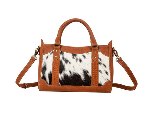 a handbag with a cow print pattern on it