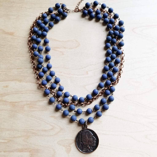 a blue beaded necklace with a coin hanging from it
