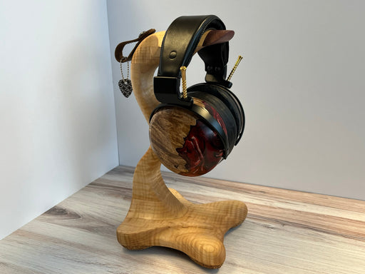 a pair of headphones on stand sitting on top of a wooden stand