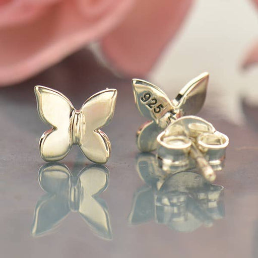 a pair of sterling silver butterfly earrings sitting on top of a table
