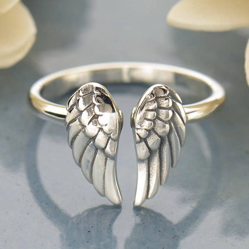 a silver ring with two angel wings on it