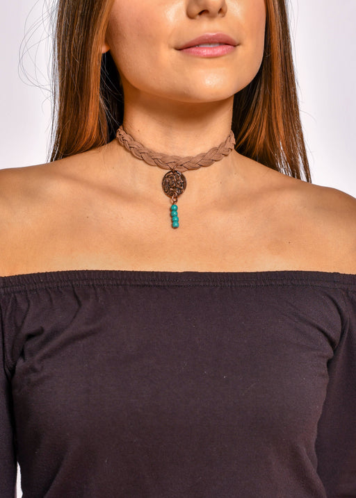 a woman wearing a brown shirt and a turquoise beaded choker necklace