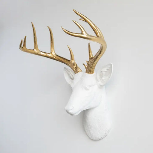 a white and gold deer head mounted on a wall