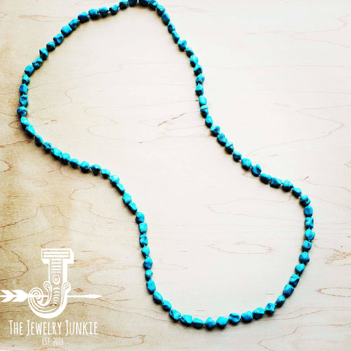 a blue beaded necklace on a wooden surface