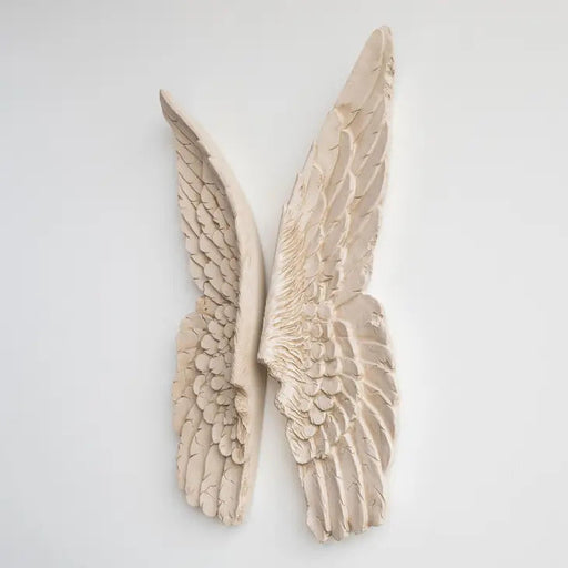 a pair of ivory distressed angel wings on a white wall