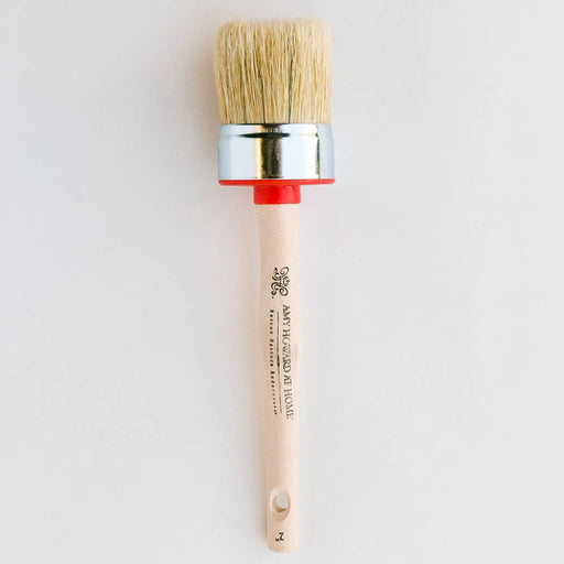 a round hog hair paint brush with a wooden handle on a white background