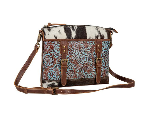 a brown and blue purse with a cow print design