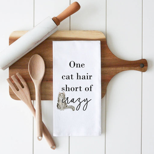 a tea towel that says one cat hair short of crazy