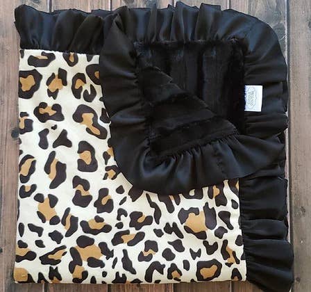 a black and white leopard print baby blanket with black ruffle