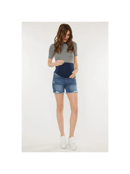 a pregnant woman in a grey shirt and denim shorts