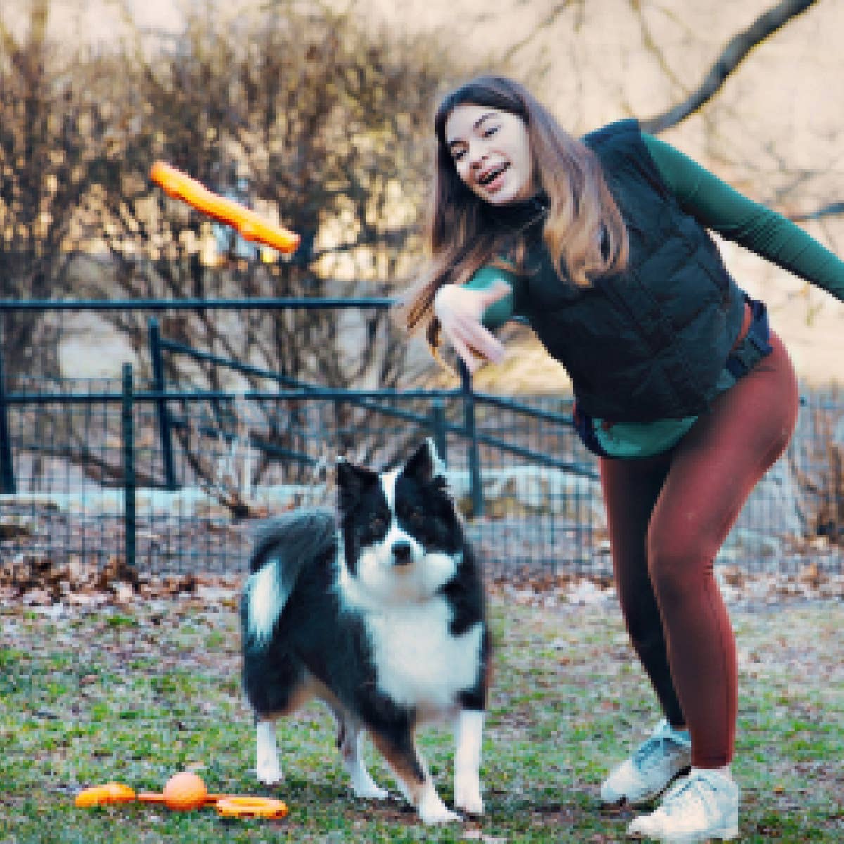 a woman is playing frisbee with a dog