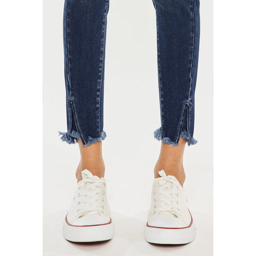 a woman's legs in jeans and white sneakers