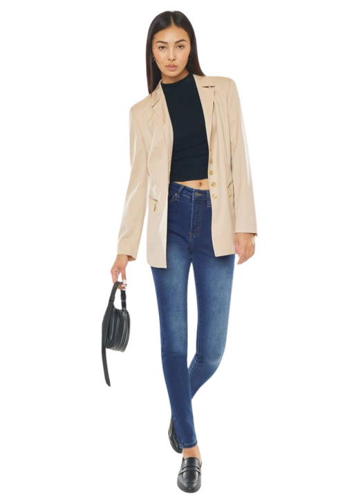 a woman in a jacket and jeans holding a purse