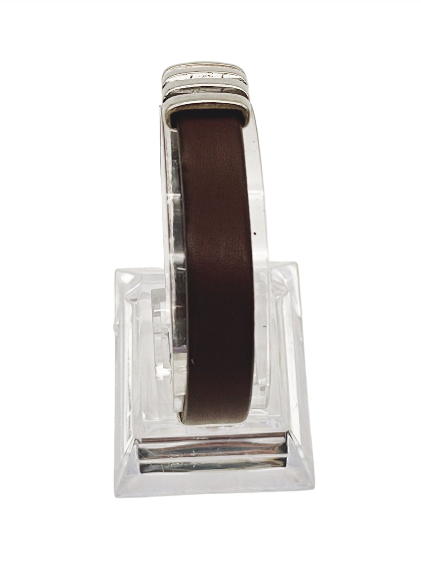 a brown leather bracelet sitting on top of a glass block