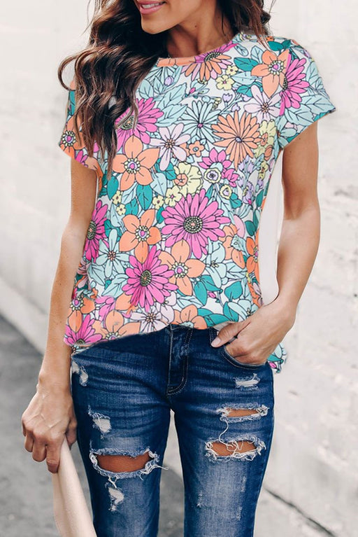 a woman wearing a floral top and ripped jeans