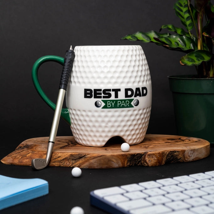 a golf mug sitting on top of a wooden board next to a keyboard