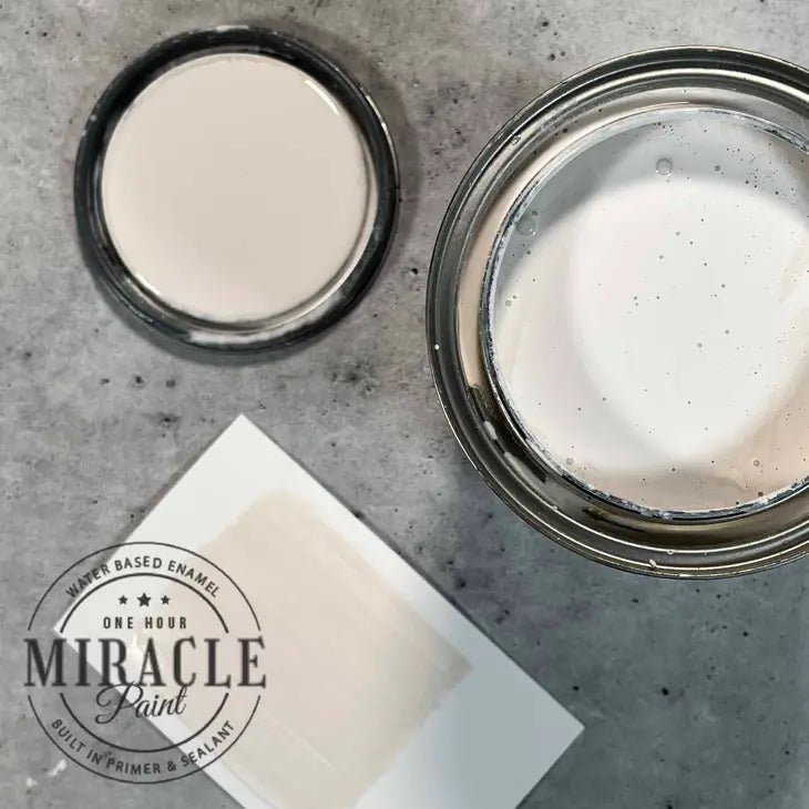 a couple of jars of white paint sitting on top of a table