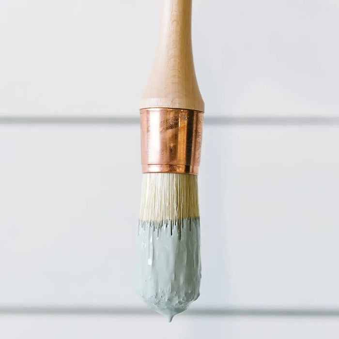 a paint brush on a white background with paint on it