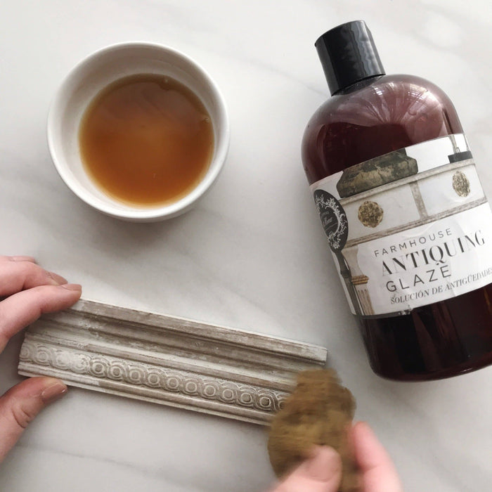 a cup of antiquing glaze and a bottle of antiquing glaze on a table