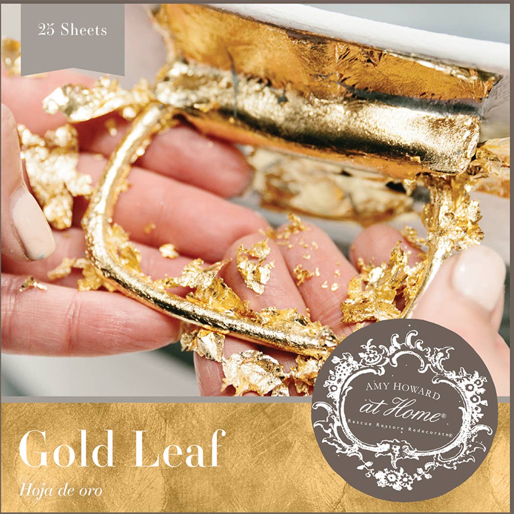 a hand holding a piece of gold leaf