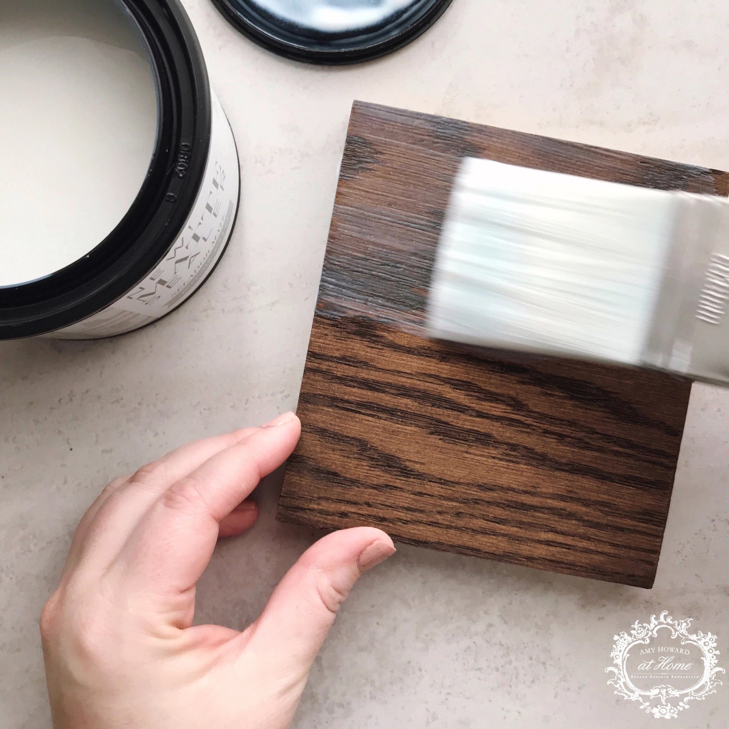 a person using a brush to paint a wooden block