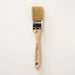 a paint brush with a wooden handle on a white background