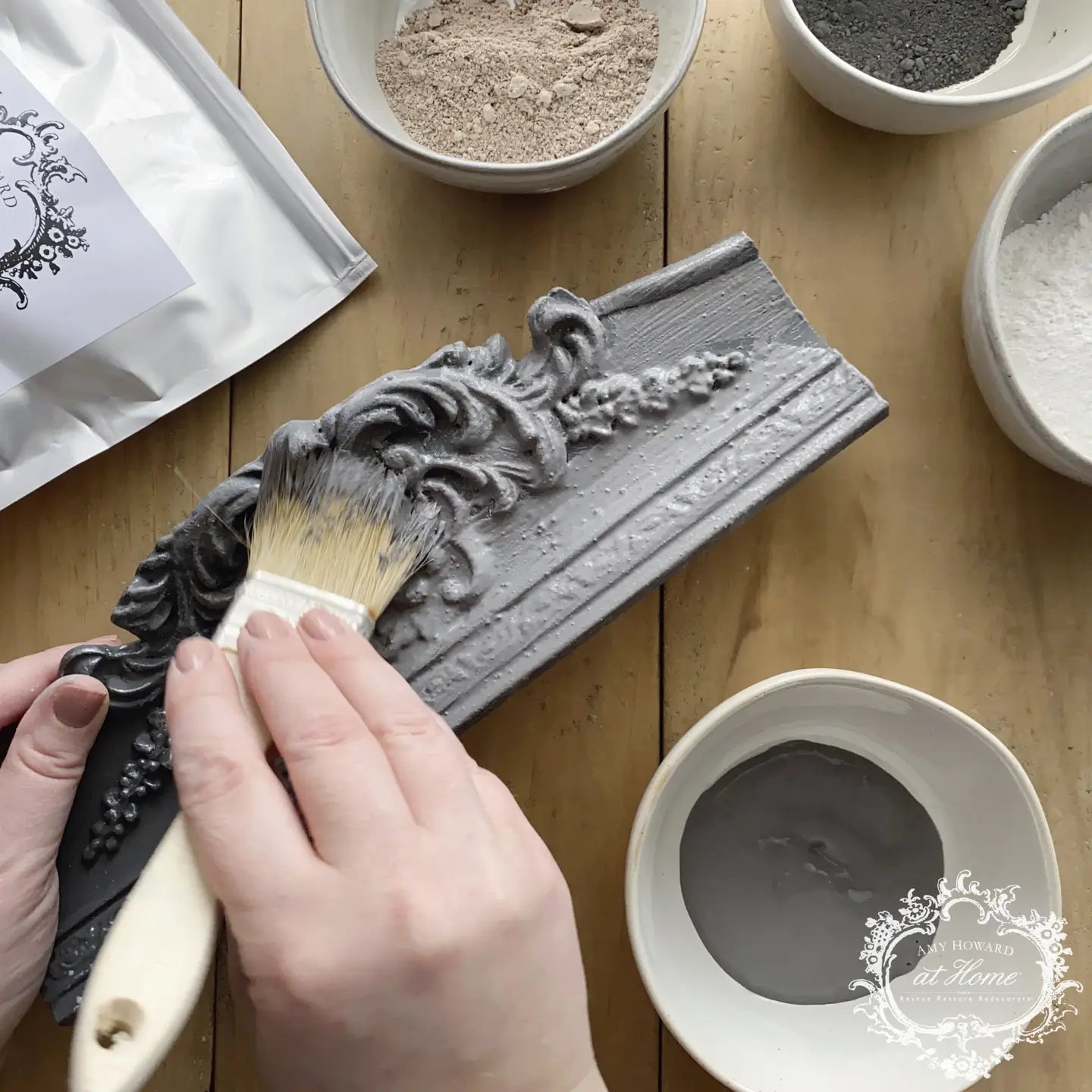 a person using a brush to paint a piece of wood