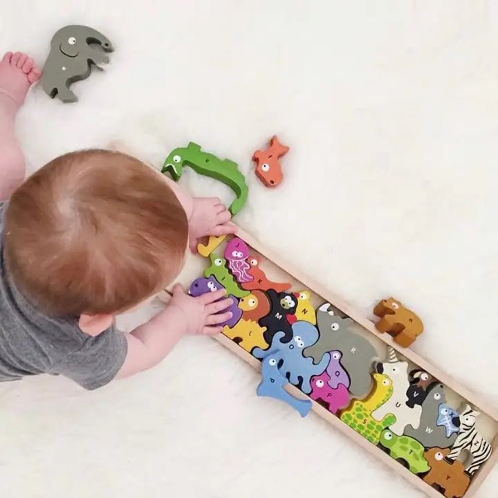 a baby playing with a wooden toy with numbered animals on it