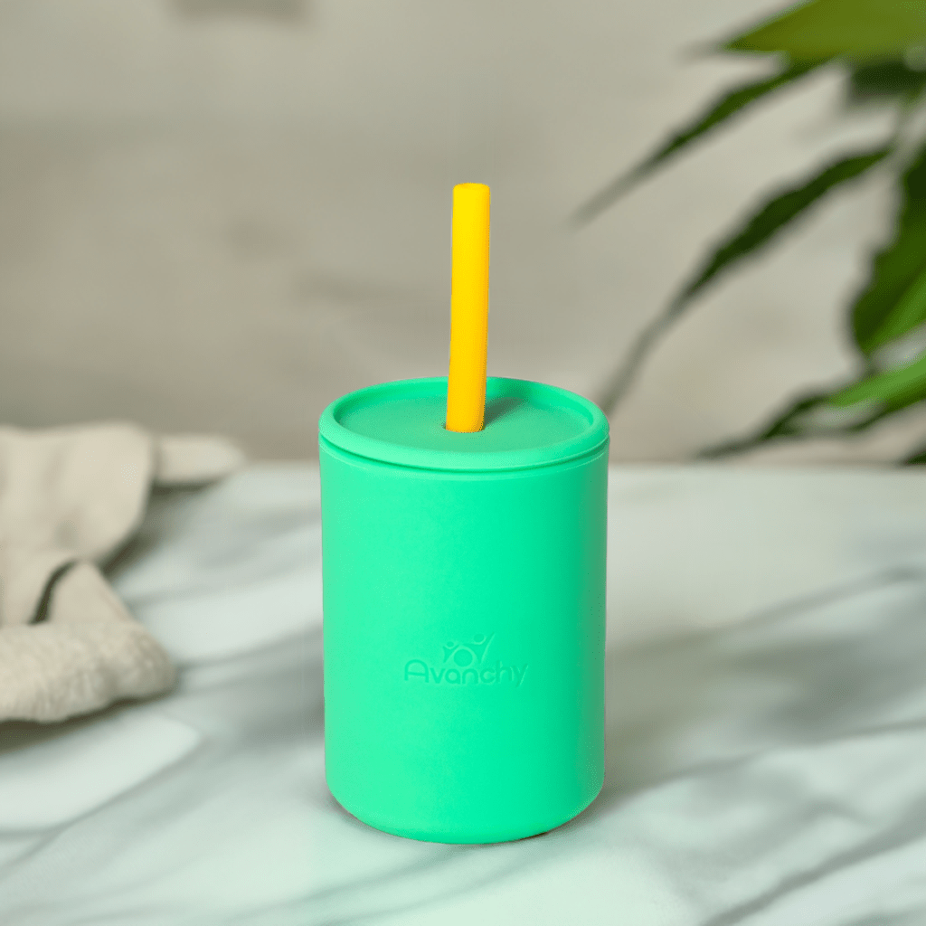 a green cup with a yellow straw in it