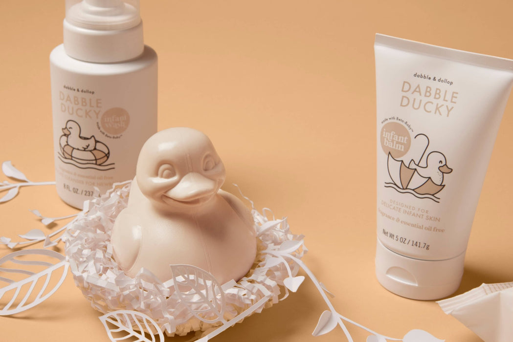 a small rubber duckie sitting in a nest next to a tube of lotion