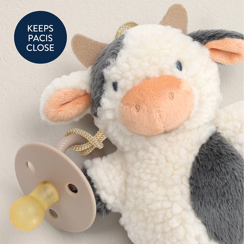 a stuffed cow with a pacifier attached to it