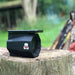 a blue speaker sitting on top of a tree stump