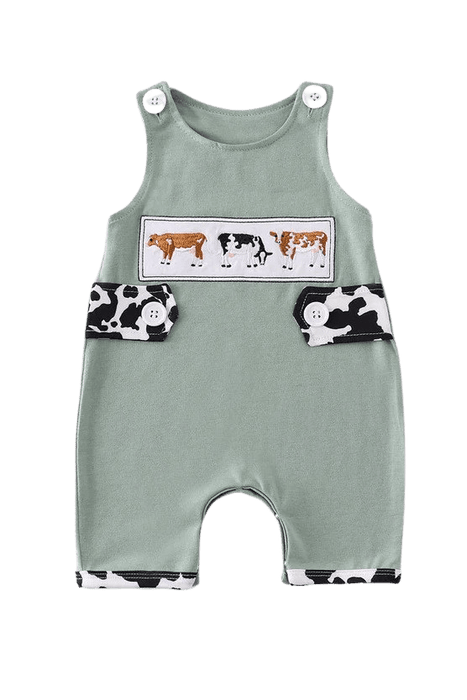 a baby romper with a cow print on it.