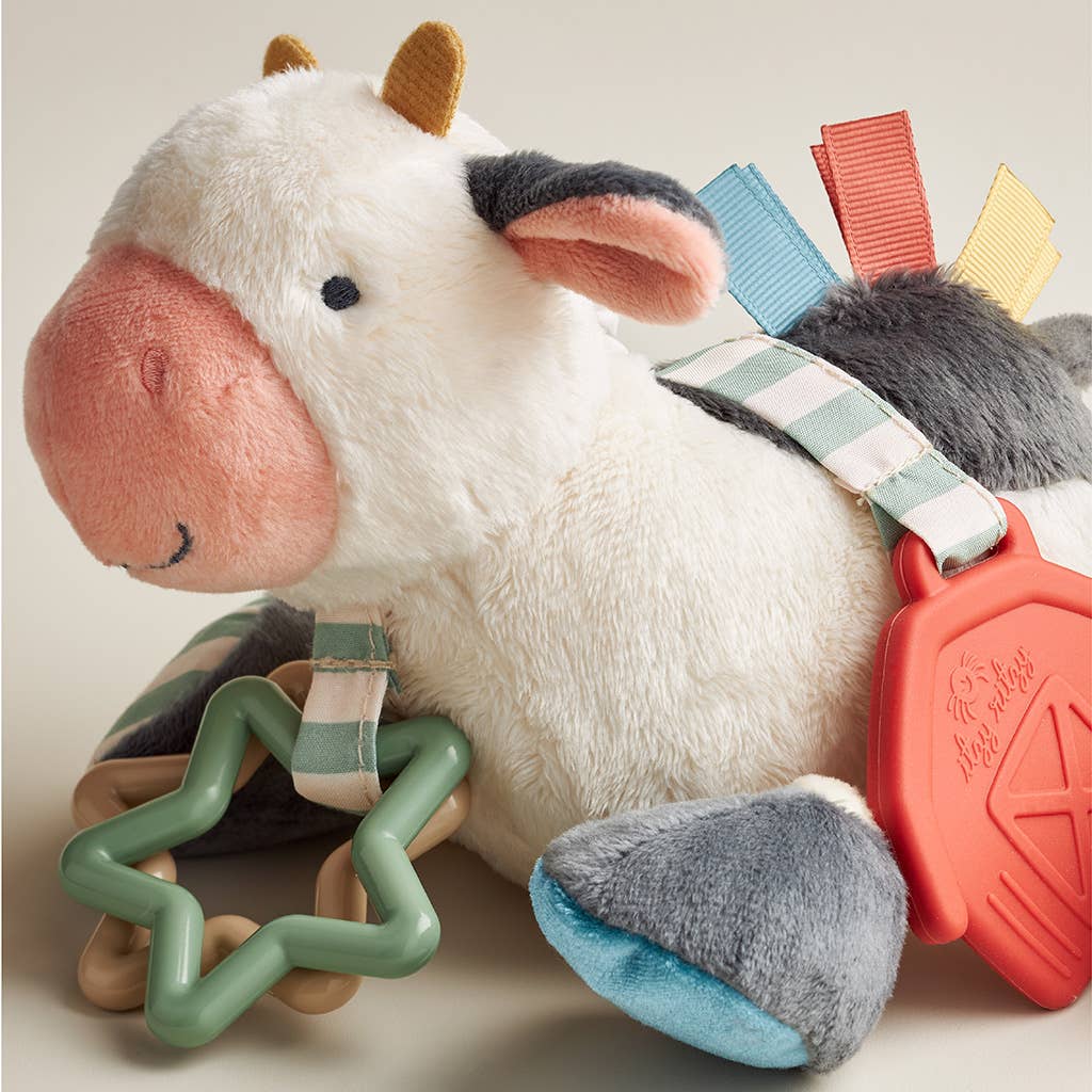 a stuffed cow laying next to a toy star