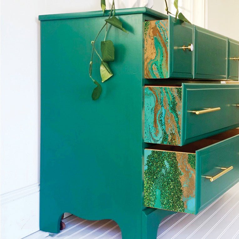 a green chest of drawers with a plant on top of it