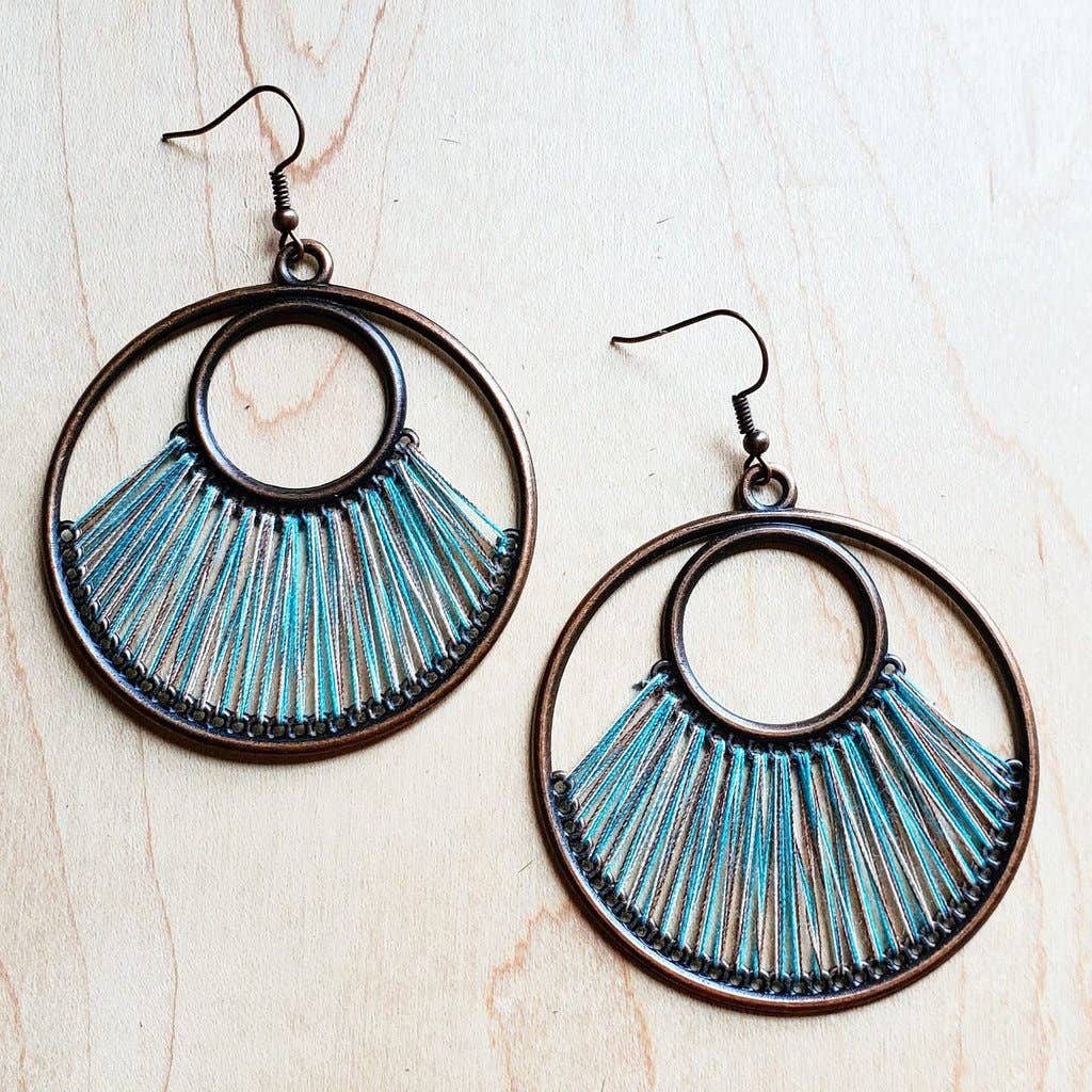 a pair of earrings on a wooden surface