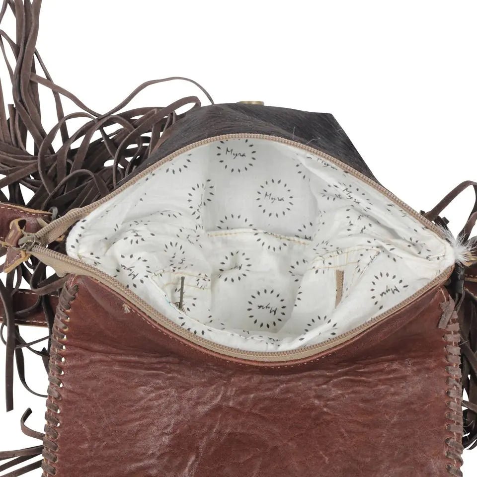 a brown leather purse with fringes on the inside of it