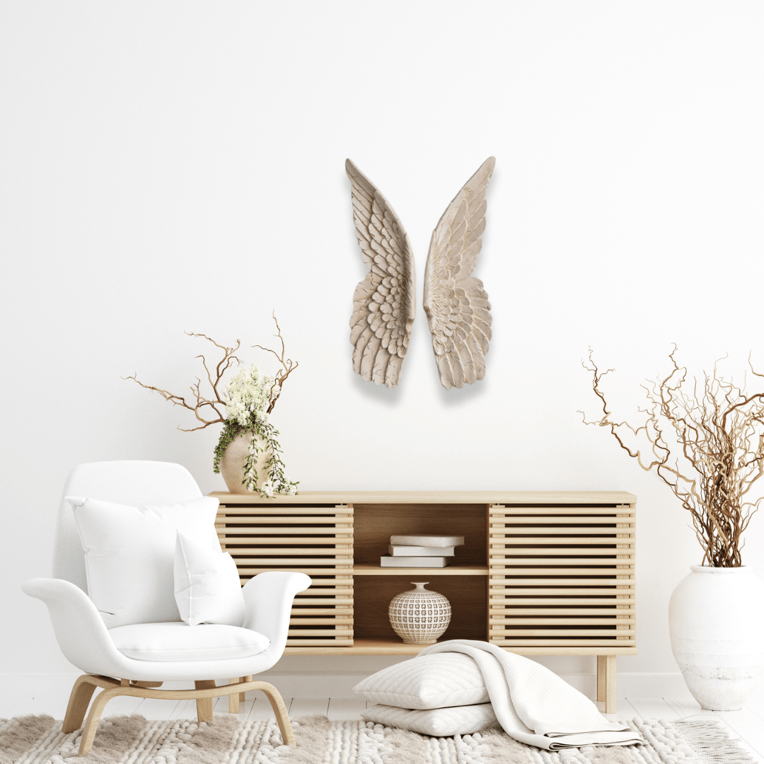 a living room with a white chair and a wooden cabinet with ivory angel wings on the wall