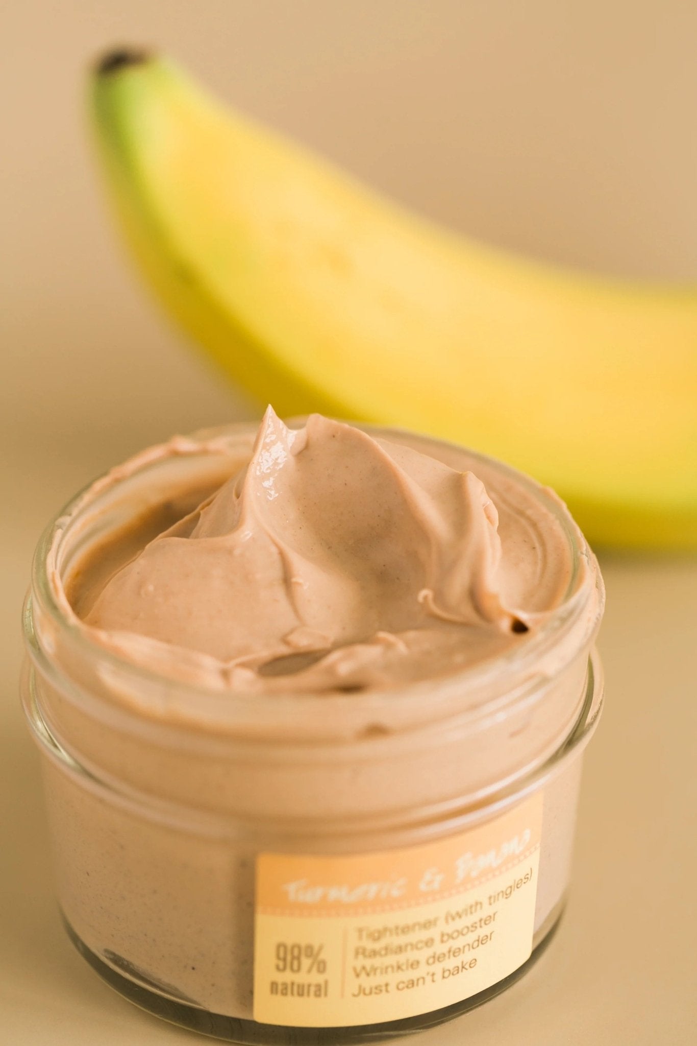 a banana sitting next to a jar of mighty tighty cream