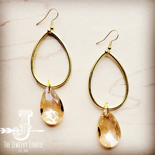 a pair of gold colored earrings with a tear shaped drop