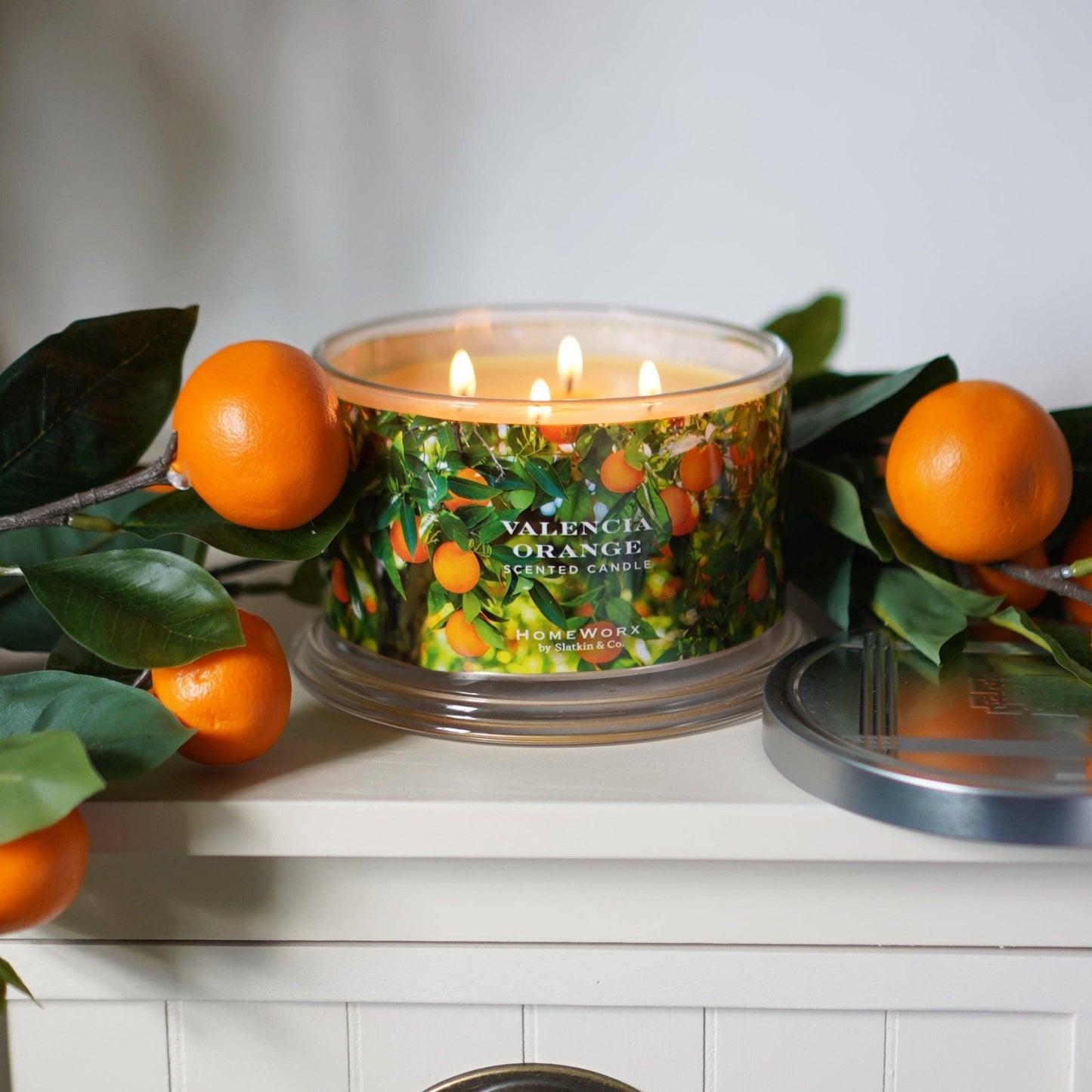 a candle surrounded by oranges