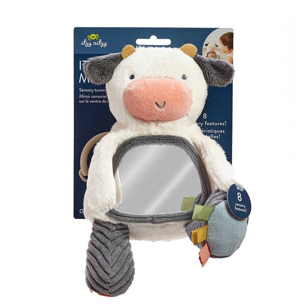 a stuffed cow is holding a mirror