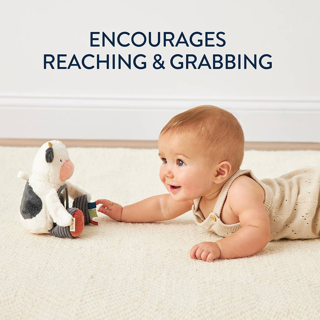 a baby is playing with a toy cow