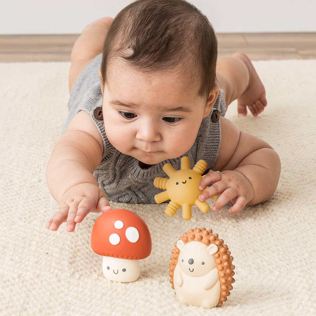 a baby laying on the floor with toys