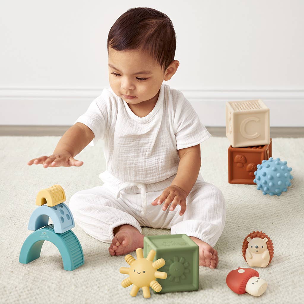 a baby sitting on the floor playing with toys