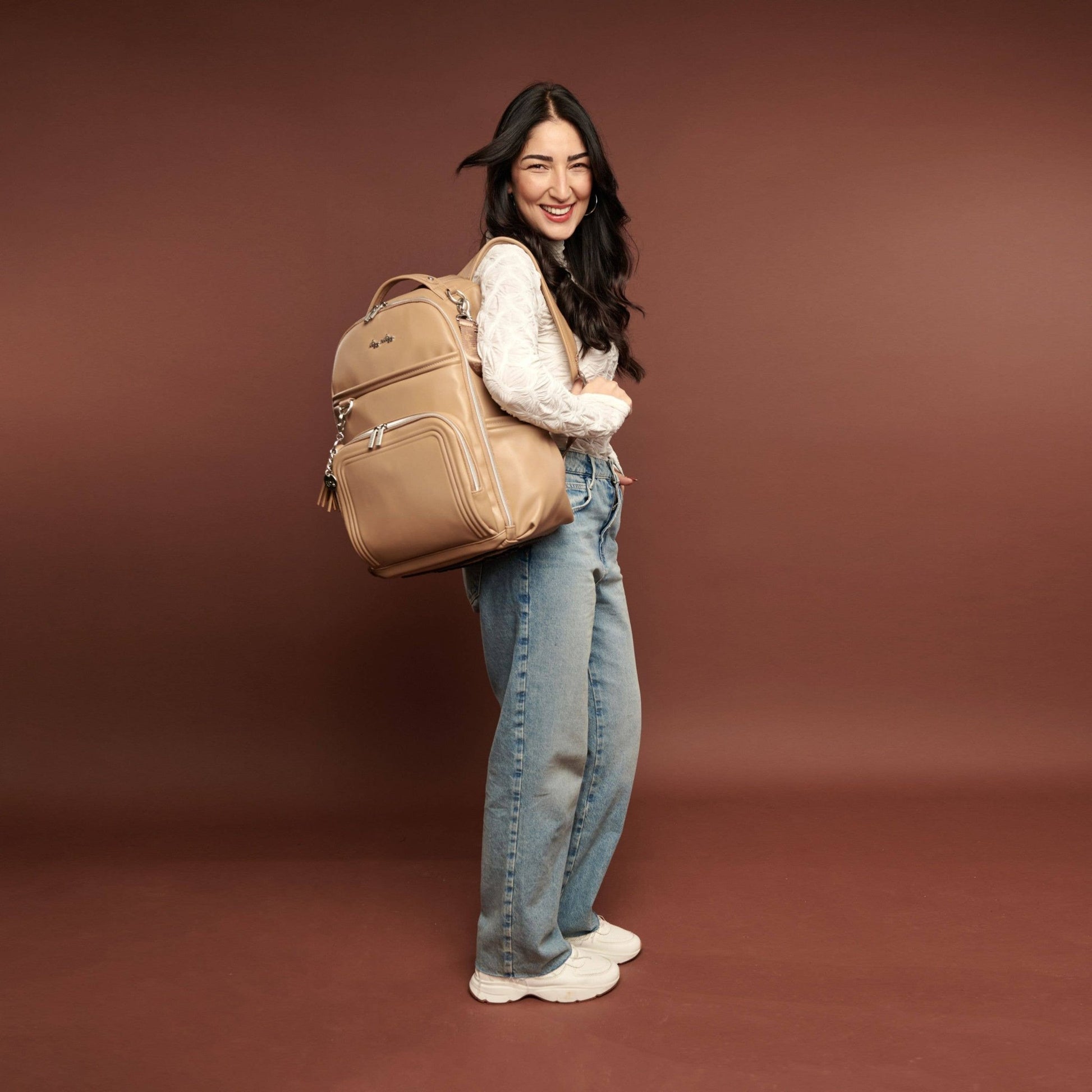 a woman is holding a brown bag and smiling