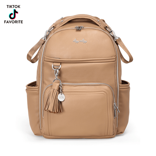 a tan backpack with a tassel on the front